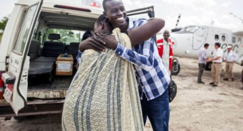 Emmanuel, 17, hugs his mother as they reunite after more than three years, forced apart by South Sudan's civil war which began in 2013.  By ALBERT GONZALEZ FARRAN AFP