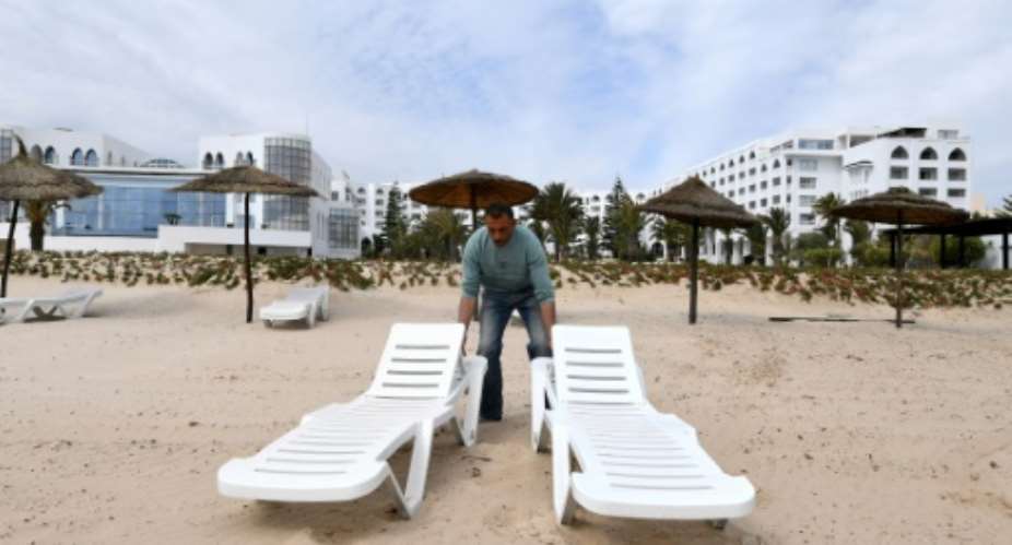 Employees arrange sun loungers on April 21, 2017 on the beach of the newly reopened Tunisian hotel where a gunman killed 38 tourists nearly two years earlier.  By FETHI BELAID AFP
