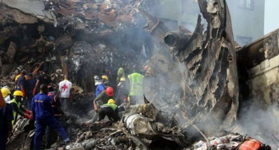 Rescuers and firefighters work the scene.  By Emmanuel Arewa (AFP)