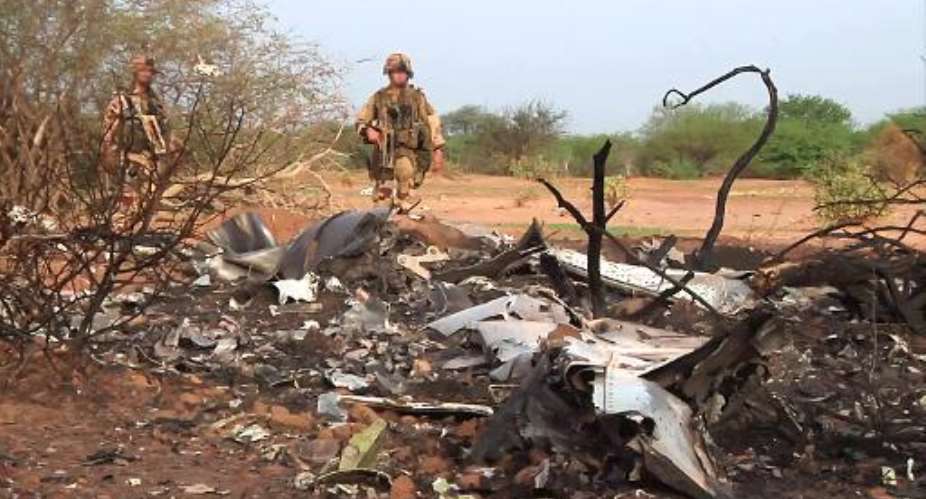 Photo released on July 25, 2014 by the  French Army Communications Audiovisual office ECPAD shows French soldiers standing by the wreckage of the Air Algerie flight AH5017 which crashed in Mali's Gossi region, west of Gao, on July 24.  By  ECPADAFP