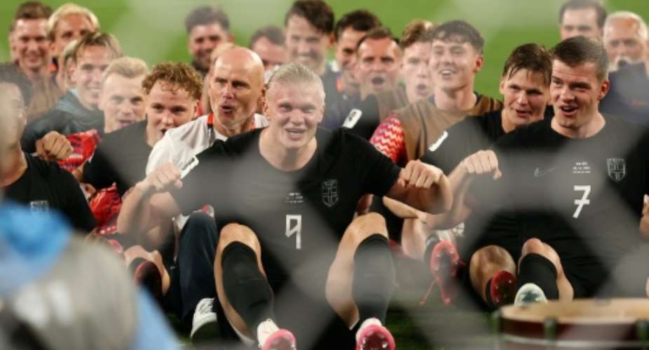 Erling Haaland led his Norway teammates in their Viking row celebration after they defeated Senegal to reach the World Cup knockout rounds.  By CHARLY TRIBALLEAU (AFP)