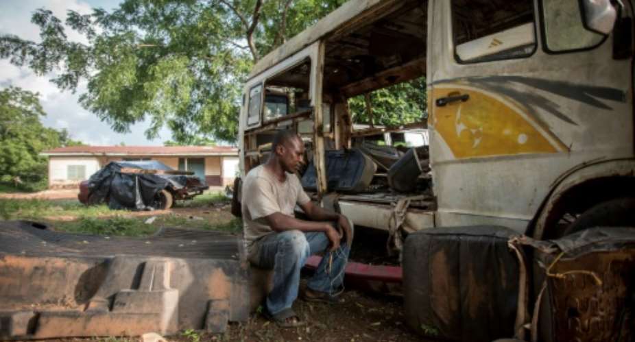 Ernest Yaw Owusu, 38, sits in his car workshop in Ghana and says if he had the money he would go to Libya and then try to get to Europe.  By CRISTINA ALDEHUELA AFP