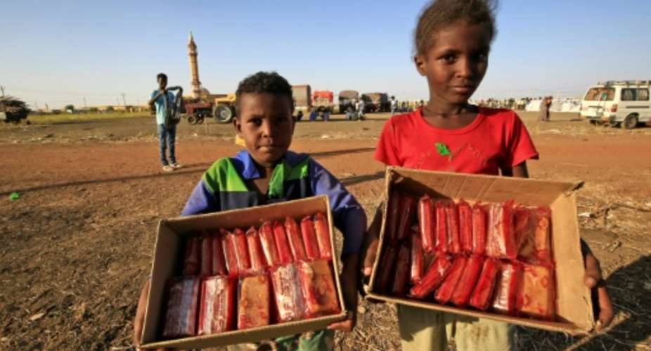 Ethiopian children selling mini cakes in Village Eight -- an east Sudan transit settlement that has grown into the size of a small town with the refugee influx.  By ASHRAF SHAZLY AFP