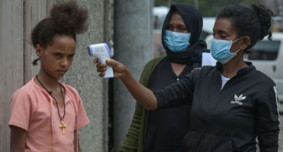 Ethiopian health ministry take a girl's temperature during door-to-door screening in Addis Ababa.  By Michael Tewelde AFPFile