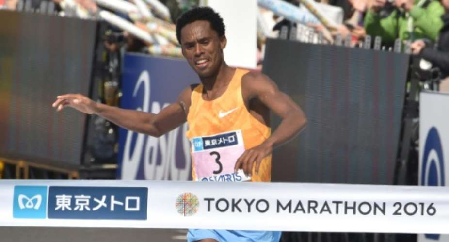 Ethiopia's Feyisa Lilesa celebrates as he prepares to cross the finish line and win the men's category of the Tokyo Marathon in Tokyo on February 28, 2016.  By Kazuhiro Nogi AFP