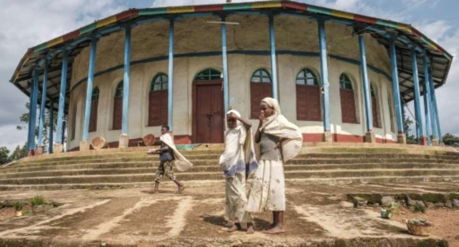 Ethiopian Orthodox devotees stand outside a church in Anderacha, once the site of a palace of the Kaffa kingdom near the town of Bonga in southern Ethiopia.  By EDUARDO SOTERAS AFP