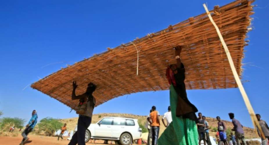 Ethiopian refugees who fled the Tigray conflict build huts in Sudan's Um Raquba camp.  By ASHRAF SHAZLY AFP