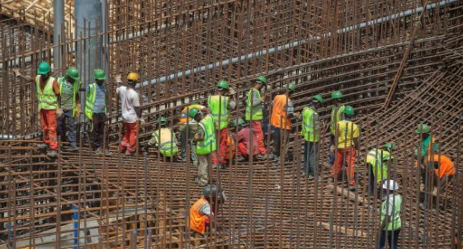 Ethiopian workers stand on scaffolding in 2015 during the construction of the Grand Renaissance Dam.  By ZACHARIAS ABUBEKER AFPFile