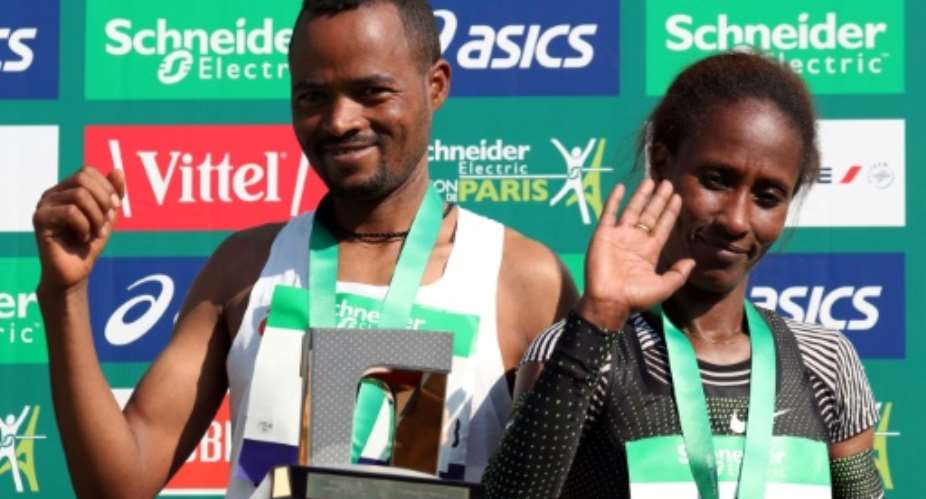 Ethiopia's Abrha Milaw and Gelete Burka celebrate their victories in the Paris marathon.  By KENZO TRIBOUILLARD AFP