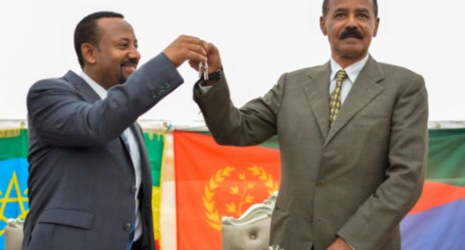 Ethiopia's Prime Minister Abiy Ahmed hands the keys of the Addis Ababa embassy to Eritrea's President Isaias Afwerki.  By MICHAEL TEWELDE AFP