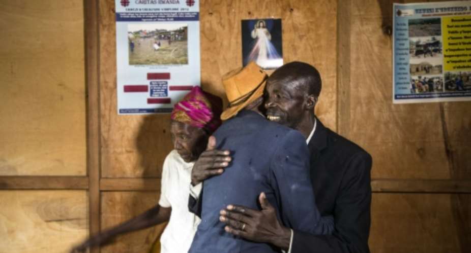 Ethnic Tutsi Jean-Bosco Gakwenzire in the hat, 65, embraces Pascal Shyirahwamaboko, 68, who was among the killers of his father at Mutete, where the old schoolfriends have now reconciled.  By JACQUES NKINZINGABO AFPFile