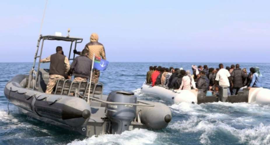Libyan coast guards escort a boatload of migrants, who had hoped to set off to Europe with the help of people smugglers from the coastal town of Garabulli, on June 6, 2015.  By Mahmud Turkia AFPFile
