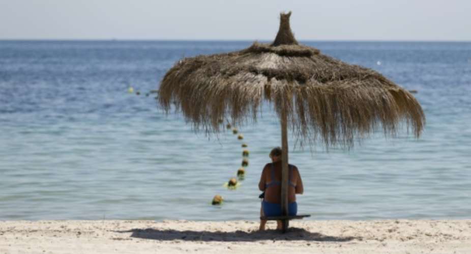 A tourist sits of the beach at the Riu Imperial Marhaba Hotel in Port el Kantaoui, on the outskirts of Sousse on June 29, 2015.  By Kenzo Tribouillard AFP