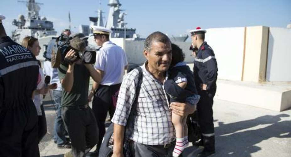 A man and his child arrive at the naval base in Toulon, southeastern France, on August 1, 2014 after being evacuated from Libya.  By Bertrand Langlois AFP
