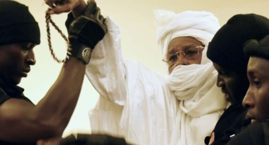 Former Chadian dictator Hissene Habre C is escorted by prison guards into the courtroom for the first proceedings of his trial by the Extraordinary African Chambers in Dakar on July 20, 2015.  By Seyllou Diallo AFPFile