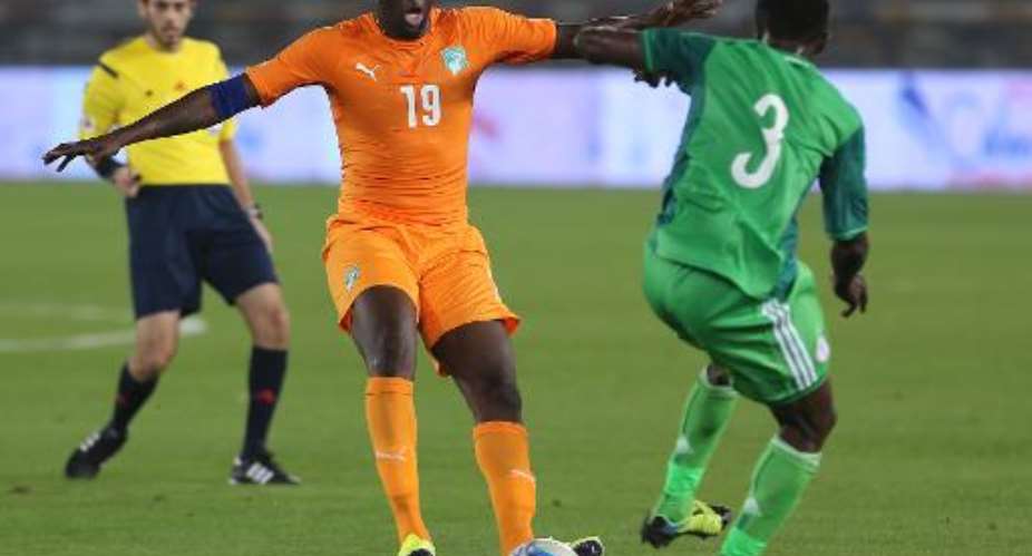 Ivory Coast's Toure Yaya C fights for the ball with Nigeria's Akas Chima Uche during their international friendly match in preparation for the Africa Cup of Nations, at the Zayed Sports City in Abu Dhabi, on January 11, 2015.  By - AFP