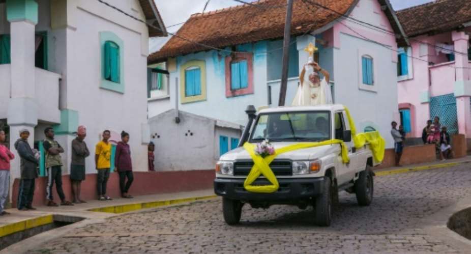 Father Pedro hopped on the back of a four-wheel drive and paraded through the town of Akamasoa.  By RIJASOLO AFP