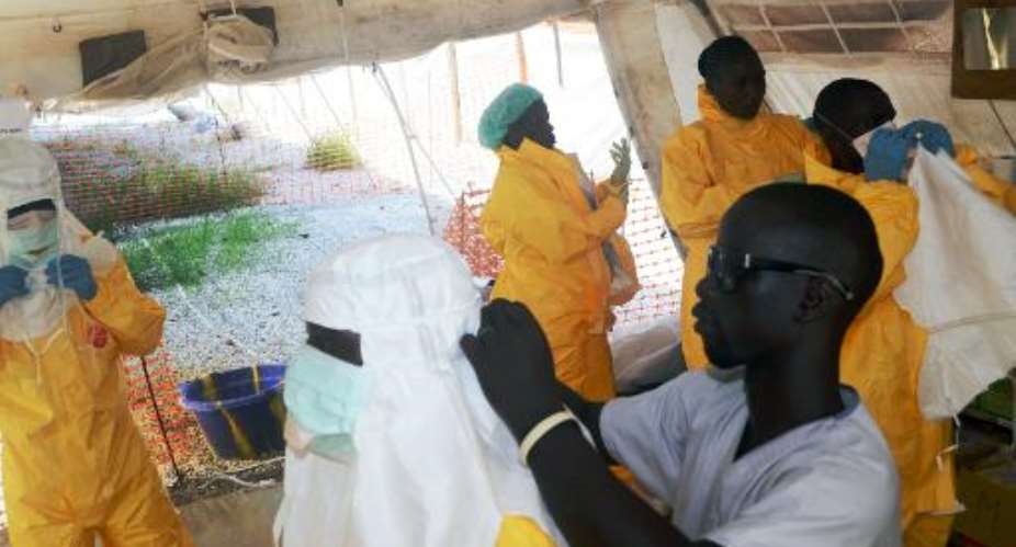 Members of Doctors Without Borders putting on protective gear at the isolation ward of the Donka Hospital in Conakry on June 28, 2014.  By Cellou Binani AFPFile