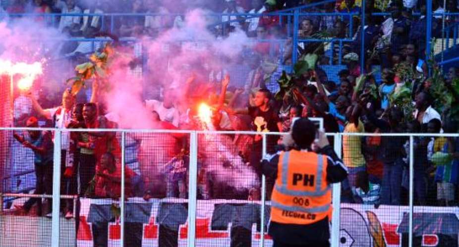 Fans use flares and shout slogans during a football match on April 6, 2013 at the stadium in Kinshasa.  By Junior D. Kannah AFPFile