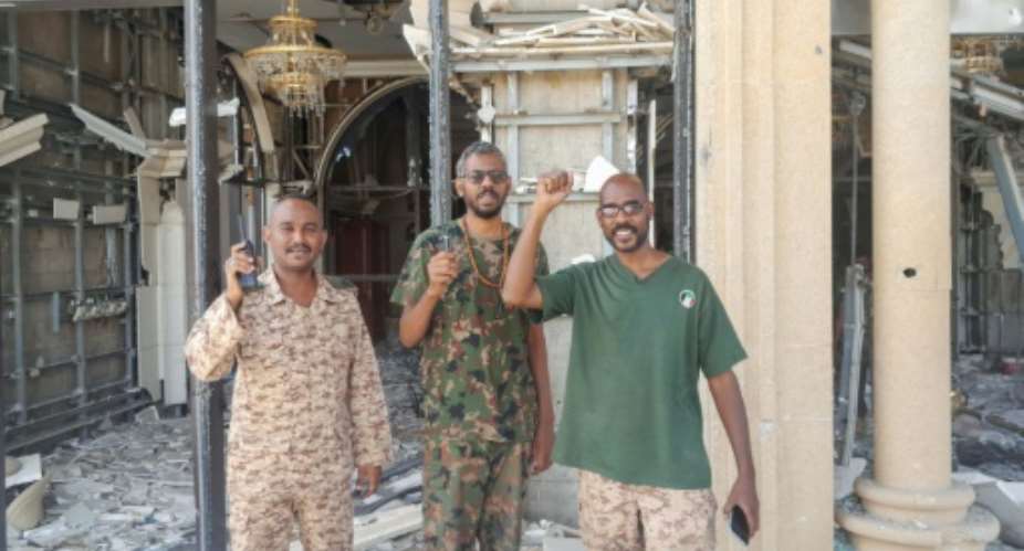 Fighters loyal to Sudans regular army pose for photographs at the presidential palace in Khartounm after its recapture from the paramilitary Rapid Support Forces on Friday..  By - (AFP)