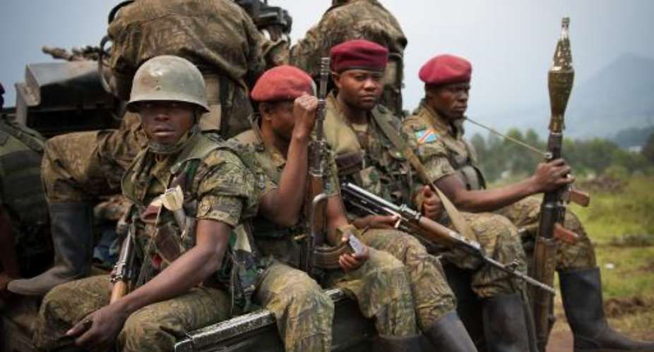 Soldiers from the Armed Forces of the Democratic Republic of the Congo (FARDC) sit in a personnel carrier on the road between Goma and Rutshuru, near the village of Kibumba I, around 20km from Goma, on July 11, 2012.  By Phil Moore (AFP/File)