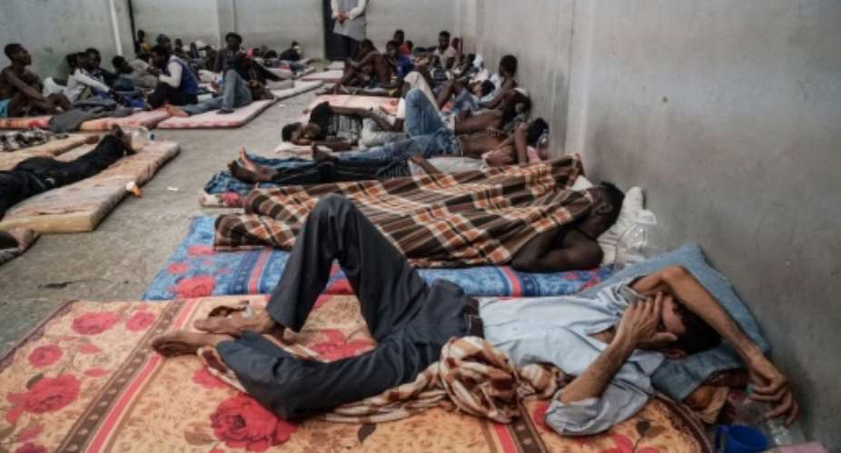 FILES In this file photo taken on June 17, 2017 illegal immigrants are seen sleeping at a detention centre in Zawiyah, 45 kilometres west of the Libyan capital Tripoli. The heads of two refugee agencies have called for refugees and migrants held in Libyan centres to be freed and for countries to take them in.  By Taha JAWASHI AFPFile