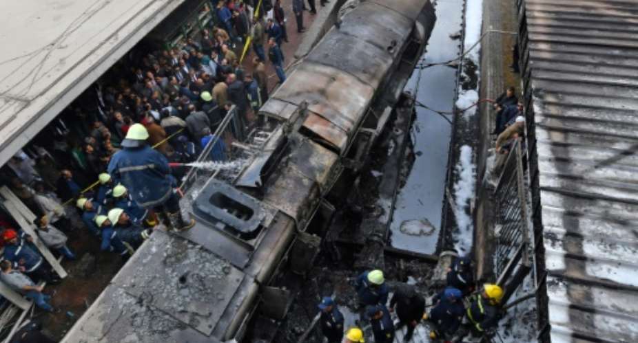 Firefighters and onlookers at the scene of a  train crash in Cairo's main rail station last month.  By STRINGER AFPFile