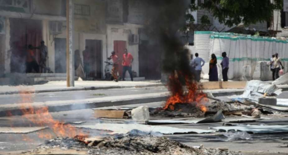 Fires are seen on a street following protest against the shooting by security forces of a rickshaw driver and his passenger, on April 13, 2019 in Mogadishu. Somali security forces shot dead a rickshaw driver and his passenger in the capital on Saturday and killed another four people who were protesting against the shootings, witnesses and lawmakers said.  By Abdirazak Hussein FARAH AFP