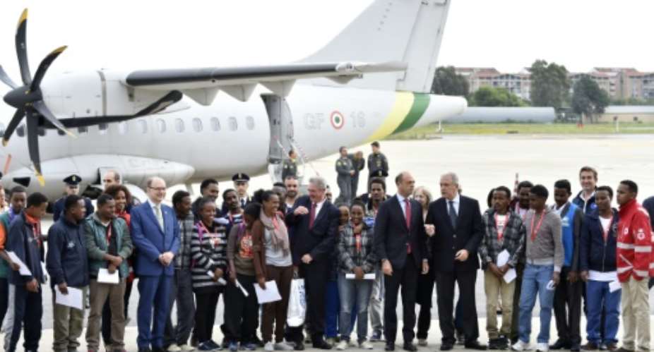 Italian Interior Minister Angelino Alfano 7thR and other officials pose with a group of Eritrean refugees before they travel to Sweden as part of a new EU relocation programme.  By Andreas Solaro AFP