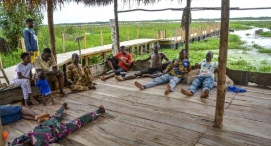 Fishermen rest under a straw hut on the tourist circuit for Porto-Novo green city which is treatening to push them off the lagoon banks.  By Abadjaye Justin SODOGANDJI (AFP)