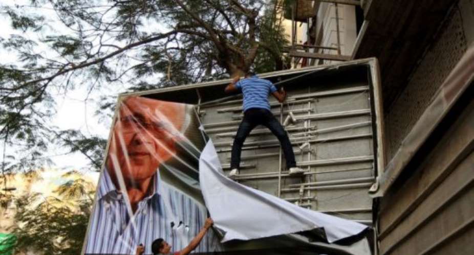Egyptian protesters tear down a poster of presidential candidate Ahmed Shafiq in Cairo.  By Marwan Naamani AFP