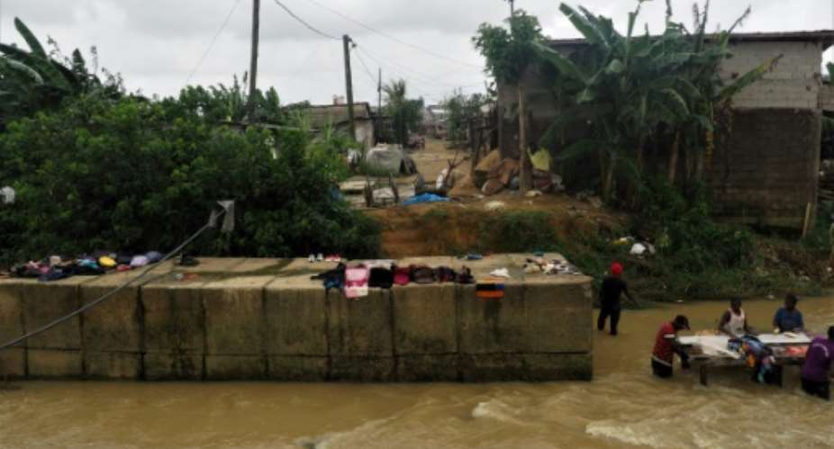 Floods are more frequent in a poor Douala neighbourhood where residents dried their belongings next to the river that flooded days earlier.  By Adrien MAROTTE AFP