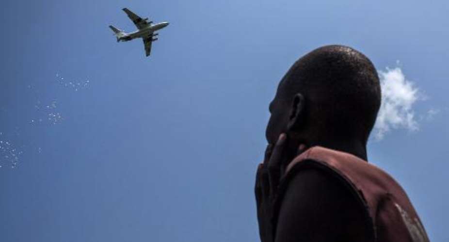 A man looks at an International Red Cross plane dropping emergency food supplies in Leer, South Sudan, on July 5, 2014.  By Nichole Sobecki AFPFile