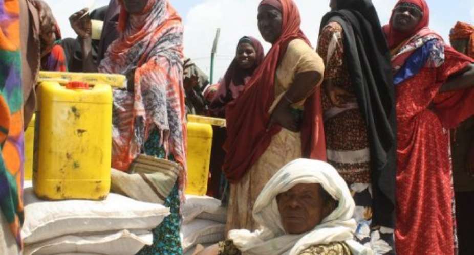 An elderly Somali sits as other women receive food-aid at a distribution station in Mogadishu.  By Abdurashid Abdulle AFPFile