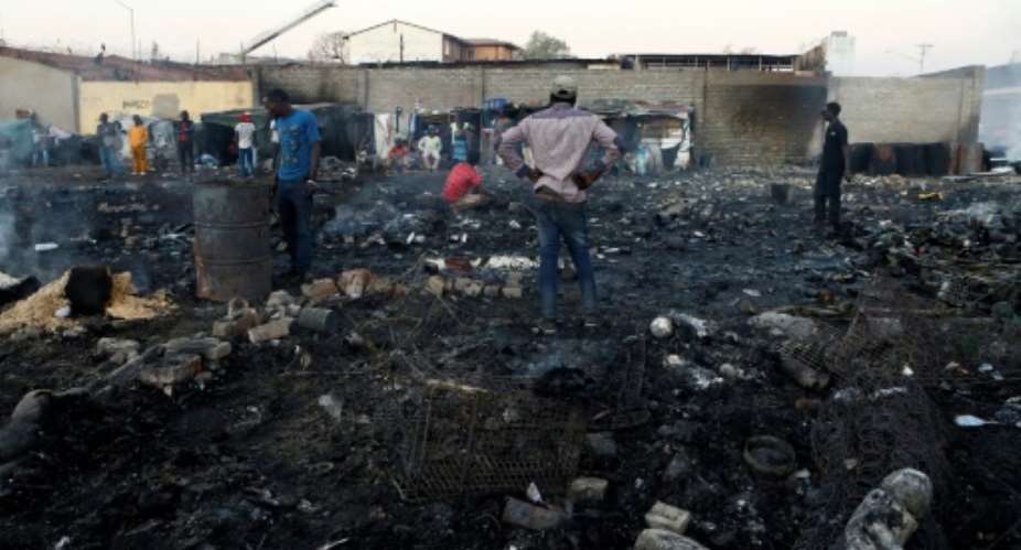 Foreigners in Marabastad, in the Pretoria area, try to save their belongings after their shacks were set alight in last month's attacks.  By Phill Magakoe AFP