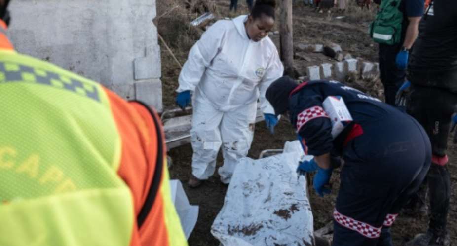 Forensics personnel write on a body bag after finding victims of the flooding near Mthatha as the death toll hit at least 78.  By EMMANUEL CROSET (AFP)