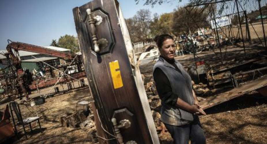 Scrapyard manager Rita Gathino stands by a coffin displayed to scare away thieves, near the main gate of her property in Cullinan, South Africa, on August 27, 2014.  By Gianluigi Guercia AFPFile