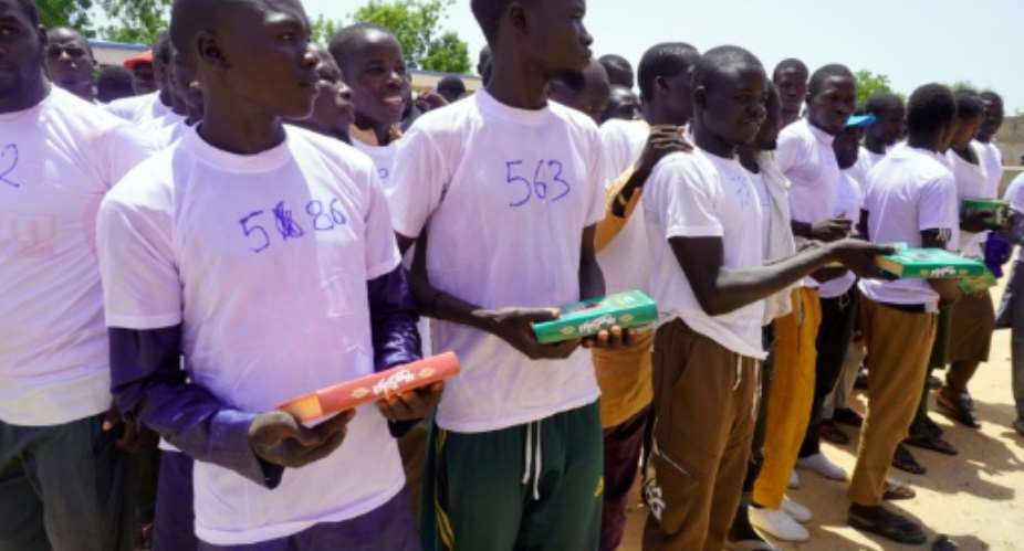 Former Boko Haram members hold the Quran at a reintegration ceremony a.  By Audu MARTE (AFP)