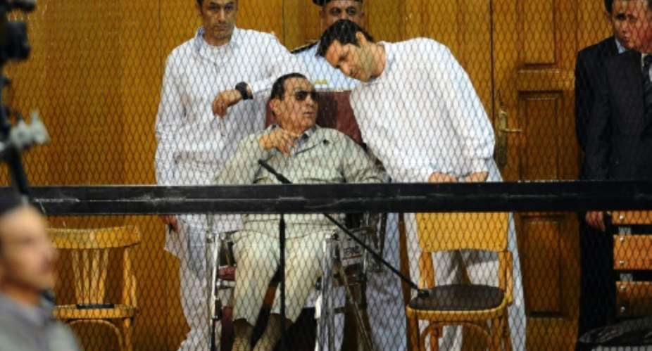 Former Egyptian president Hosni Mubarak with his two sons Alaa R and Gamal during their trial in Cairo in September 2013.  By AHMED EL-MALKY AFP