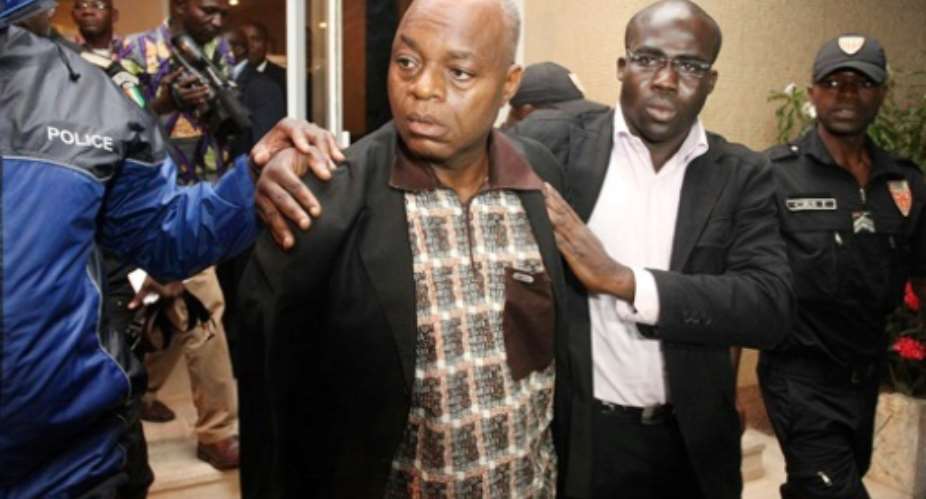 Former Ivory Coast defence chief Moise Lida Kouassi, a key ally of ex-President Laurent Gbagbo, is led away following his arrival in Abidjan in 2012 after being extradited from Togo.  By HO IVORIAN GOVERNMENT PRESSAFPFile