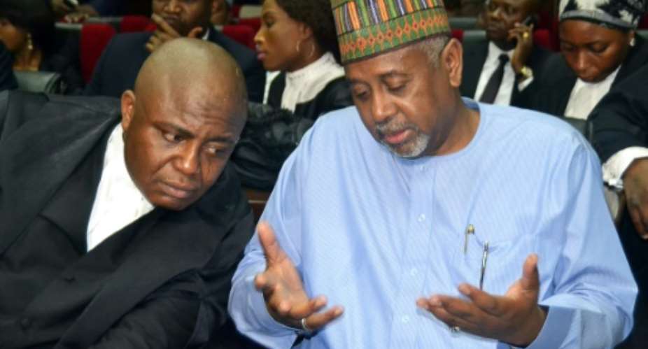 Former national security adviser of ex-president Goodluck Jonathan, Sambo Dasuki right, speaks with his lawyer Ahmed Raji, during his trial at the federal high court in Abuja, on September 1, 2015.  By STRINGER AFPFile