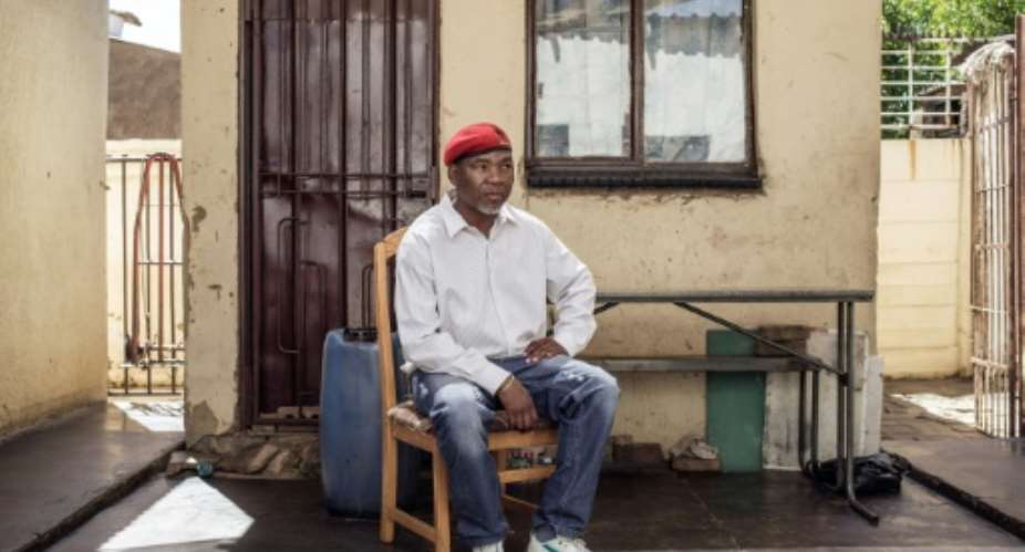 Former political prisoner and member of the Pan African Congress party, Kenny Motsamai, sits in the courtyard of his house few day after being released on parole after spending more than two decades in prison, in Ekurhuleni, in January 2017.  By GIANLUIGI GUERCIA AFPFile