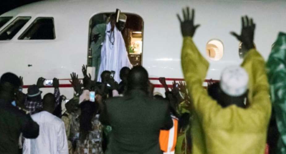 Former president Yaya Jammeh C, the Gambia's leader for 22 years, waves from the plane as he leaves the country on 21 January 2017 in Banjul.  By STRINGER AFP