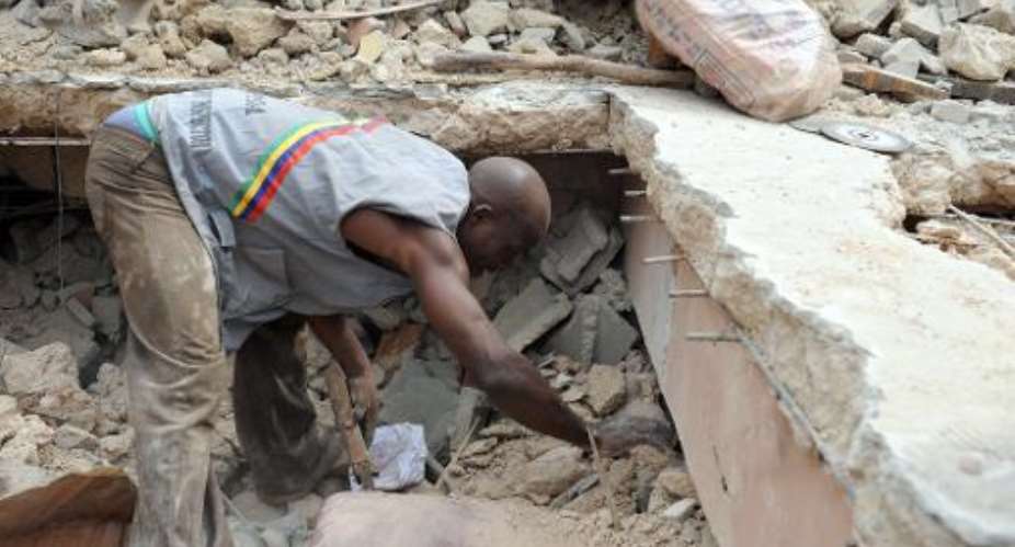 Rescue workers remove a carpet from the rubble of a collapsed four-storey building at Idumota in Lagos on July 7, 2011.  By Pius Utomi Ekpei AFPFile
