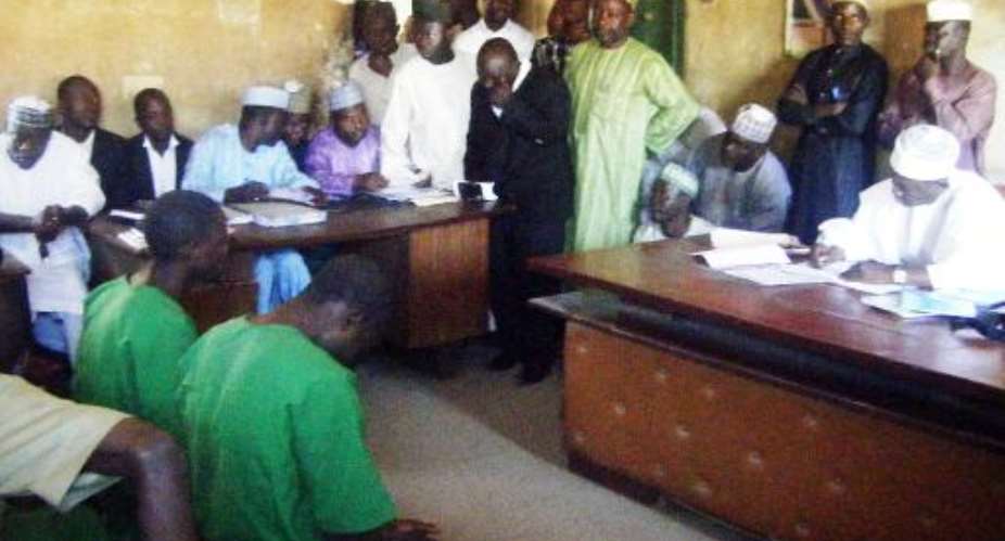 A picture taken on January 22, 2014 shows two suspected homosexuals in green prison uniforms L at Unguwar Jaki Upper Sharia Court in the northern Nigerian city of Bauchi.  By Aminu Abubakar AFPFile