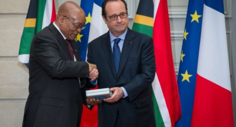 French President Francois Hollande right gives an audio recording of Nelson Mandela to South Africa President Jacob Zuma,  during a ceremony at the Elysee Palace in Paris, on July 11, 2016.  By Jeremy Lempin PoolAFP