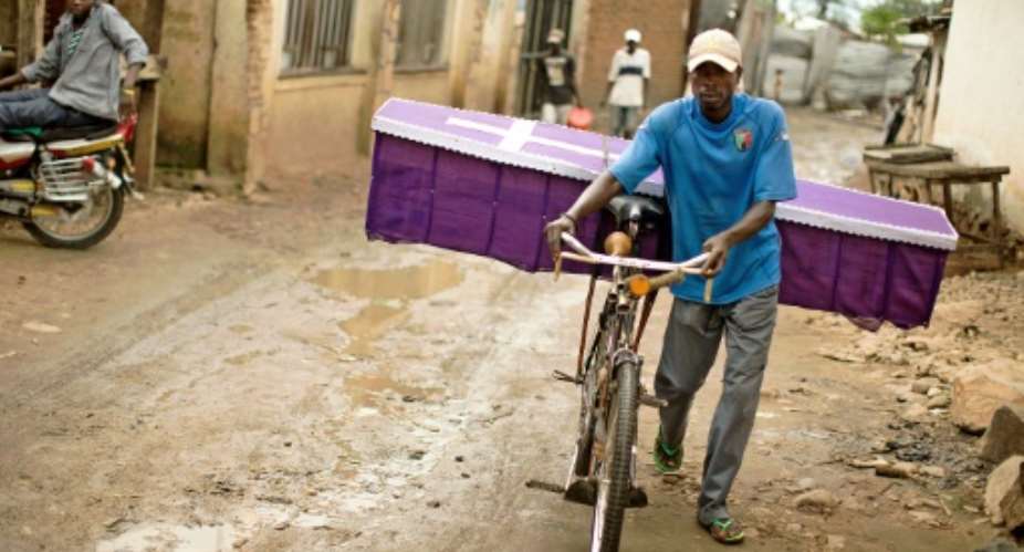 A man pushes his bicycle to deliver a coffin in the Bujumbura suburb of Kanyosha on January 10, 2016.  By Griff Tapper AFPFile