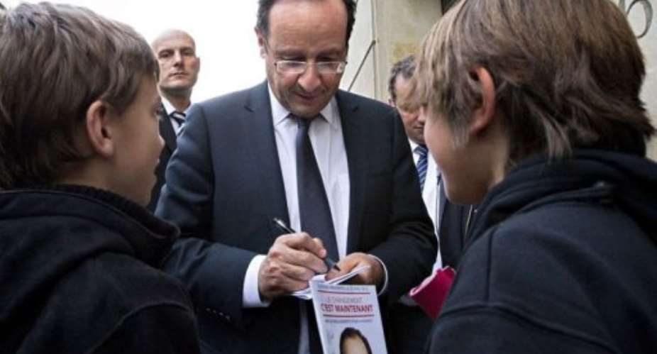 Francois Hollande signs autographs in front of his home in Paris.  By Joel Saget AFP