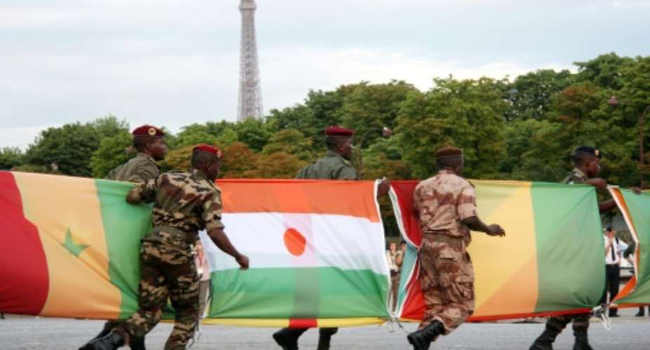 French connection: Troops carry African flags -- with Niger's at centre -- at the 2010 Bastille Day parade in Paris.  By FLORE GIRAUD AFP