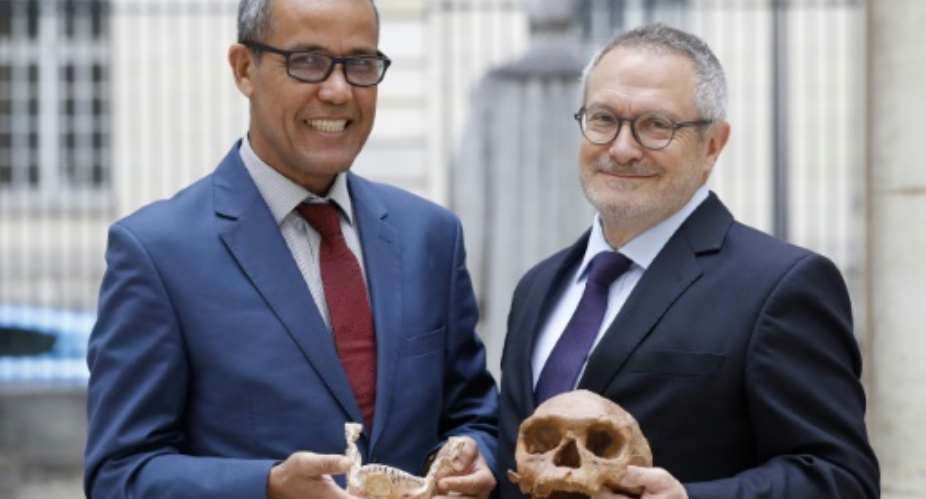 French paleoanthropologist Jean-Jacques Hublin R and Abdelouahed Ben-Ncer of the National Institute of Archaeology and Heritage Sciences in Morocco pose with the casting of a skull of Homo Sapiens discovered in Morocco on June 6, 2017 in Paris.  By PATRICK KOVARIK AFP